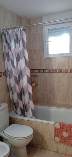 a bathroom with a toilet and a shower curtain at Bonito bajo cerca del mar in Benicarló