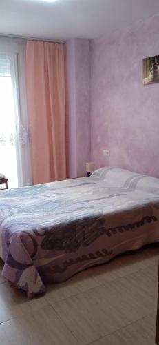 a bedroom with a large bed with pink walls at Bonito bajo cerca del mar in Benicarló