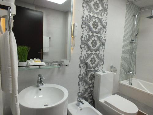 a bathroom with a sink and a toilet and a tub at Verona Resorts Sharjah in Sharjah