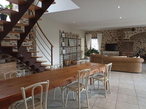 uma sala de jantar com uma mesa de madeira e cadeiras em La Maison de Lili em Loudes