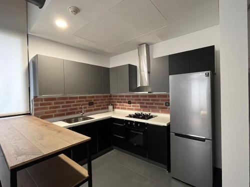 a kitchen with black cabinets and a white refrigerator at U Park 1-BR in Sin El Fil in Beirut
