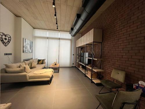 a living room with a couch and a brick wall at U Park 1-BR in Sin El Fil in Beirut