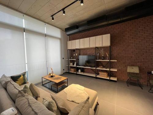 a living room with a couch and a brick wall at U Park 1-BR in Sin El Fil in Beirut