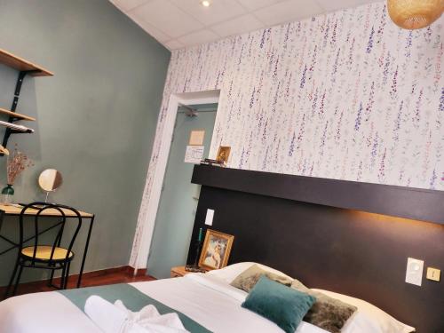 a bedroom with a bed and a wall with flowers at Hôtel Abalone - Centre Gare in Nîmes