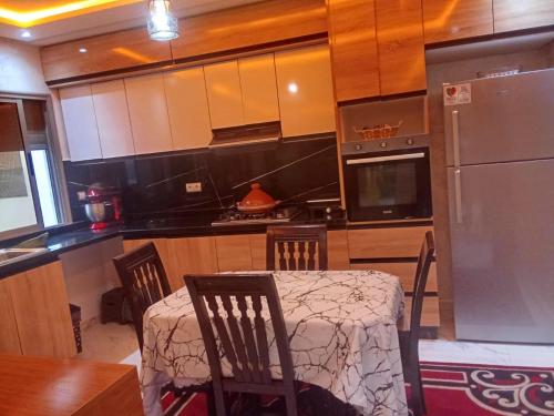 a kitchen with a table and chairs and a refrigerator at بوزنيقة in Bouznika
