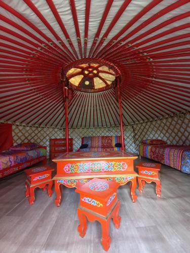 ein Zimmer mit 2 Tischen und Stühlen in einem Zelt in der Unterkunft Hébergement insolite Yourte traditionnelle mongole 
