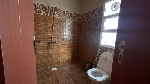 baño con aseo y ducha con ventana en استراحة عبق الاندلس, en Sayq
