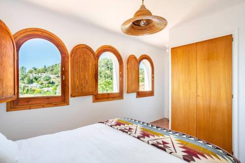 a bedroom with a bed and some windows at ThePineRooms in Arenys de Munt