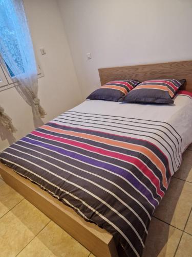 - un lit avec une couverture rayée et des oreillers dans l'établissement Belle Chambre dans une charmante Villa entièrement équipée, à Saint-Jean-de-Védas