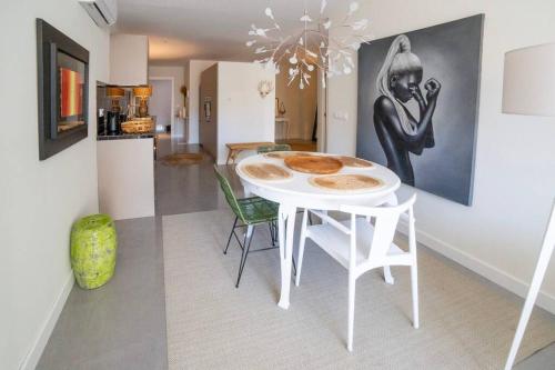 Exquisito apartamento en el centro. في غانديا: طاولة بيضاء وكراسي في مطبخ به لوحة