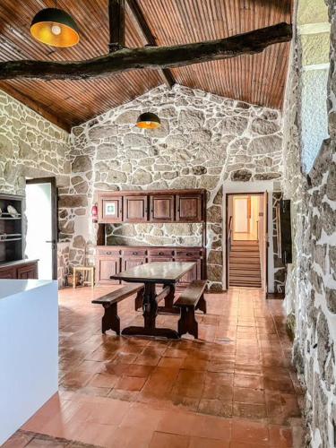 a room with a table in a stone wall at Casa da Eira by Quantique in Amares