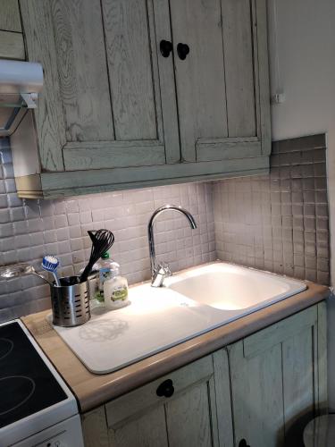 - un comptoir de cuisine avec un évier blanc et un comptoir dans l'établissement Spacieux appartement refait à NEUF - 4 pers - vue sur l'hippodrome, à Cabourg