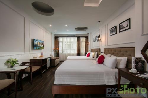 a hotel room with a large bed and a desk at Victory Legend Hotel - In Hanoi Central in Hanoi