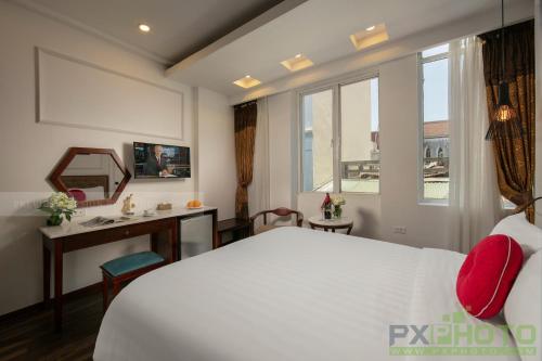 a bedroom with a bed and a desk and a window at Victory Legend Hotel - In Hanoi Central in Hanoi