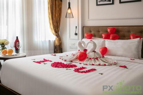 a bed with red and white stuffed animals on it at Victory Legend Hotel - In Hanoi Central in Hanoi