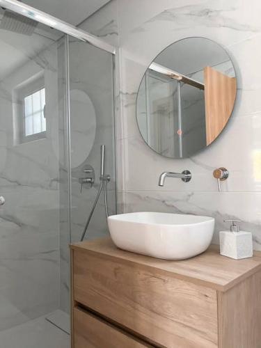 a bathroom with a white sink and a mirror at Casa da Eira by Quantique in Amares