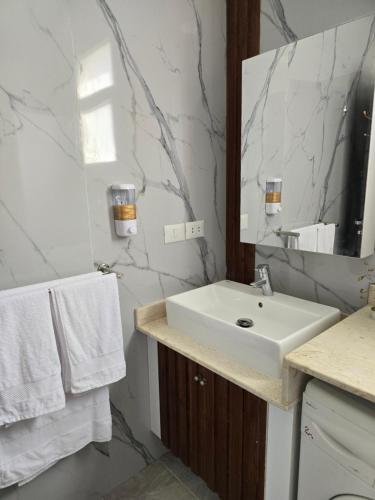 een witte badkamer met een wastafel en een spiegel bij Delights in Sharm El Sheikh