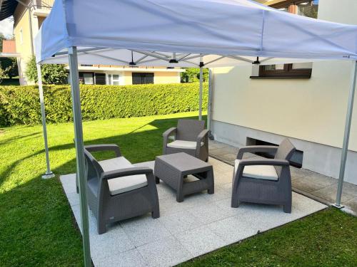 a group of chairs and tables under a blue umbrella at Apartman Tip Top in Gospić