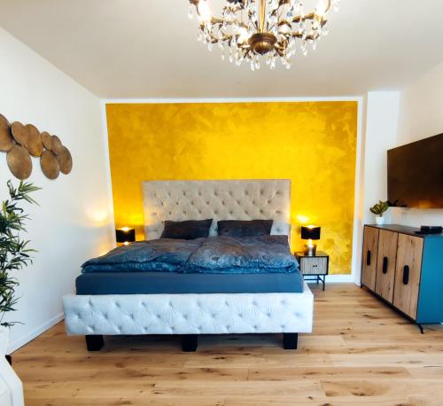 a bedroom with a bed and a yellow wall at Villa Schöneck Bad Münster in Bad Kreuznach