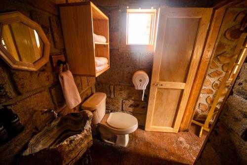 a small bathroom with a toilet and a sink at Canto del Bosque Santuario de las luciernagas in Nanacamilpa