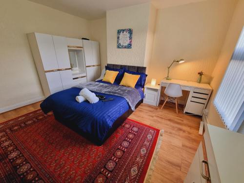 Bright sunny, double bed with garden, TV and Wi-Fi في ليدز: غرفة نوم بسرير ازرق وسجادة حمراء