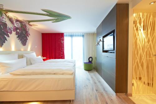 a bedroom with a white bed and a television at Hotel-Restaurant Schwanen in Metzingen