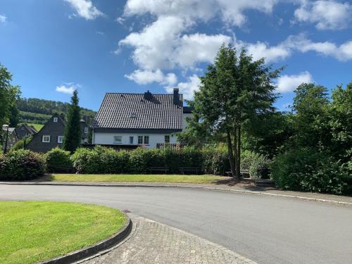 een lege weg voor een wit huis bij Landhaus am Bach in Winterberg-Silbach in Winterberg