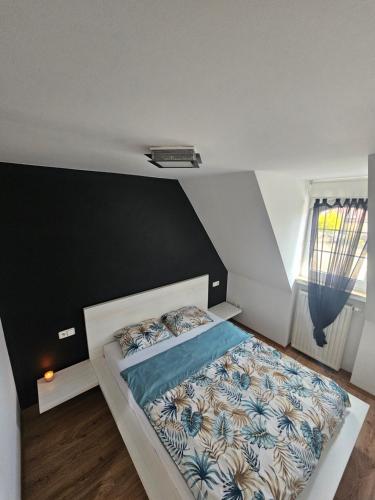 a bedroom with a bed with a black and white comforter at Na Rynku in Ślesin