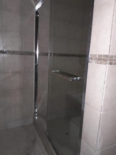 a shower with a glass door in a bathroom at Macum Guesthouse in Roodepoort
