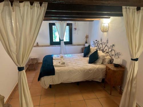 um quarto com uma cama num quarto com cortinas em Mas La Cassanya em Terrades