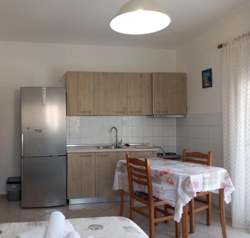 a kitchen with a table and a refrigerator at Thalia`s Apartment near the beach in Nea Kalikratia