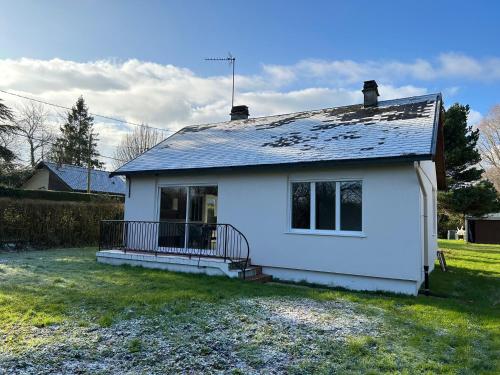a white house with a porch on a yard at Vacances au calme aux 3 Bouchots in Quend