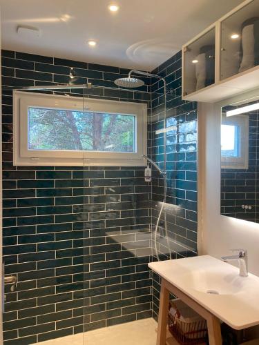 une salle de bain avec un lavabo et une douche avec du carrelage bleu dans l'établissement Vacances au calme aux 3 Bouchots, à Quend