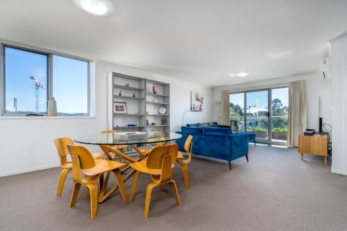 a living room with a table and chairs and a couch at Spacious and Cosy Apt with Great Views in Braddon - Hosted by CanStay in Canberra