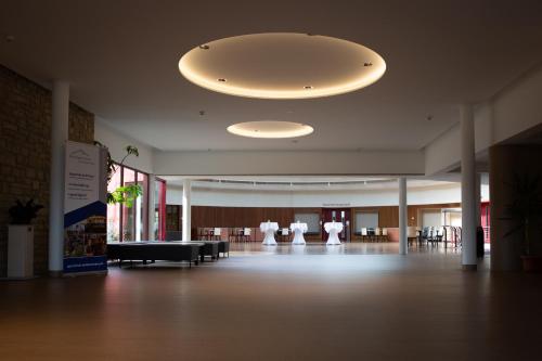 バート・ブランケンブルクにあるLandessportschule Bad Blankenburgの天井に大きな照明器具が備わる広い客室です。