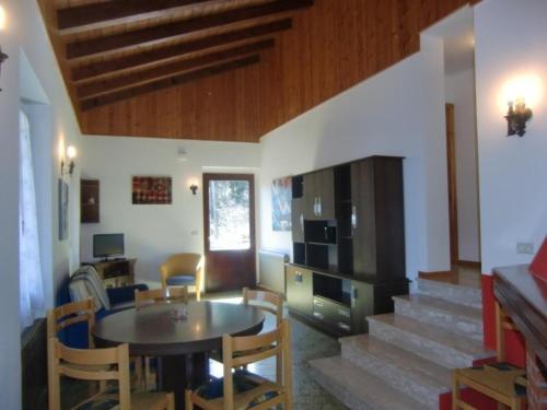 een woonkamer met een tafel, stoelen en een trap bij Appartement in Val Maria-Pur mit Großem Balkon und Seeblick in Pieve Di Ledro