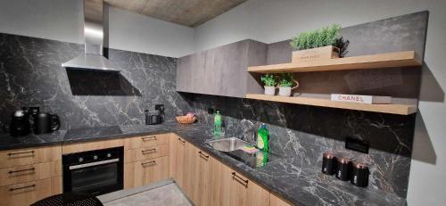 a kitchen with a black marble counter top at B8 Seaside Luxury Rooms with private bathroom - dining area shared in St Paul's Bay