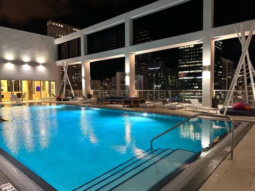 uma grande piscina no topo de um edifício com um horizonte da cidade em Luxe Loft Heart of Miami Brickell Downtown em Miami