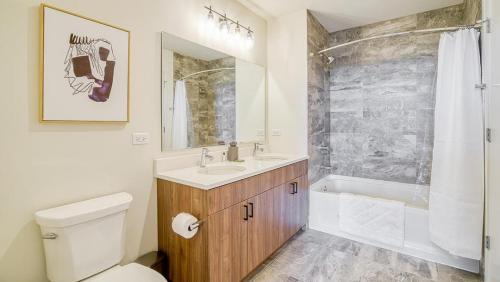 a bathroom with a toilet and a sink and a shower at Landing at Logan Apartments - 1 Bedroom in Logan Square in Chicago