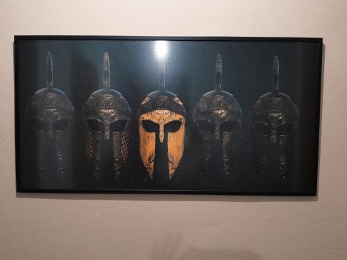 a painting of three masks hanging on a wall at Spartan Townhouse Apt 3 Leonidas in Sparti