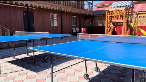 2 blauwe tafeltennistafels op een patio bij Дом Отдыха Айзада in Qabanbay