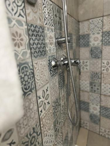 a shower in a bathroom with a glass door at Hôtel Abalone - Centre Gare in Nîmes