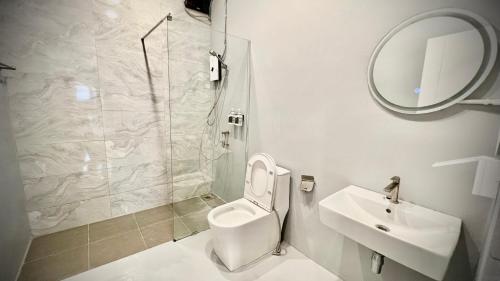 a bathroom with a toilet and a sink and a shower at Momento Hotel and Cafe in Khon Kaen