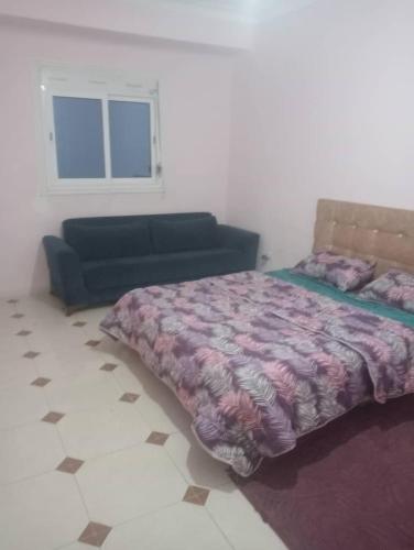 a bedroom with a bed and a couch in it at Bab ezzouar in Bab Ezzouar