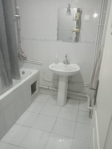 a white bathroom with a sink and a tub and a sink at Bab ezzouar in Bab Ezzouar