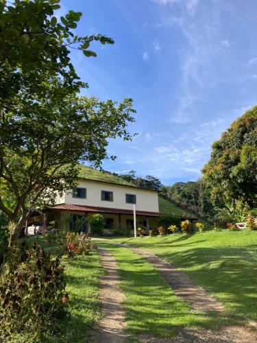 una casa con un patio de césped y un camino de tierra en Sítio Dom Pedrito, en Piraí