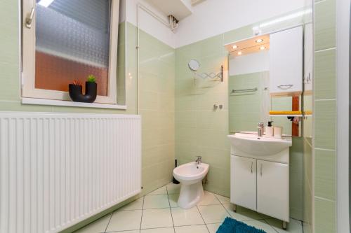 a bathroom with a toilet and a sink at R APARTMENTS BUDAPEST in Budapest