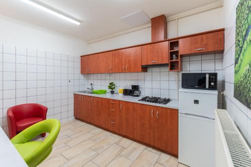 a kitchen with wooden cabinets and a red chair at R APARTMENTS BUDAPEST in Budapest