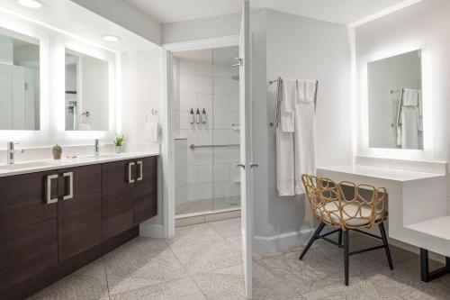 uma casa de banho com um lavatório, um chuveiro e uma cadeira. em Marriott's Newport Coast Villas em Newport Beach