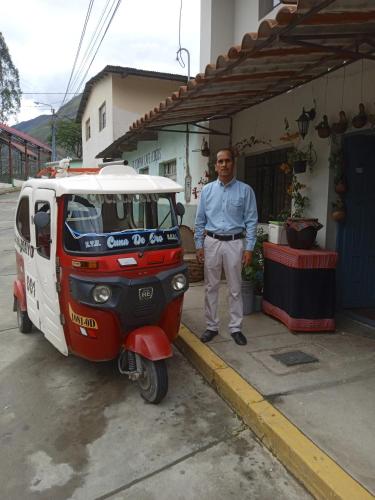 a man is standing next to a small vehicle at Hospedaje Quillabamba in Santa Teresa